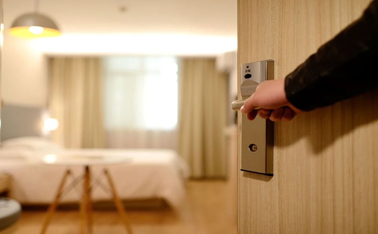 Χέρι ανοίγει την πόρτα δωμάτιου Ξενοδοχείου