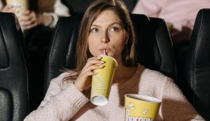 Νεαρή κοπέλλα παρακολουθει ταινίας σε αίθουσα κινηματογράφου