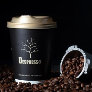 Χάρτινο ποτήρι καφέ και κόκκοι καφέ espresso