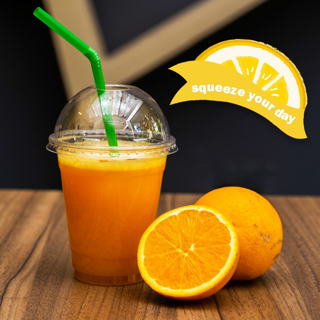 Φυσικός χυμός πορτοκάλι σε ποτήρι και κομμένο πορτοκάλι