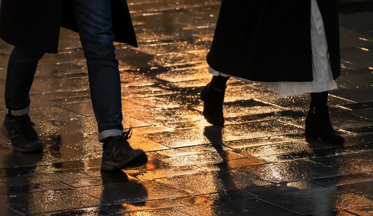 Πόδια απο ζευγάρι που βράδυ περπατά μέσα στη βροχή