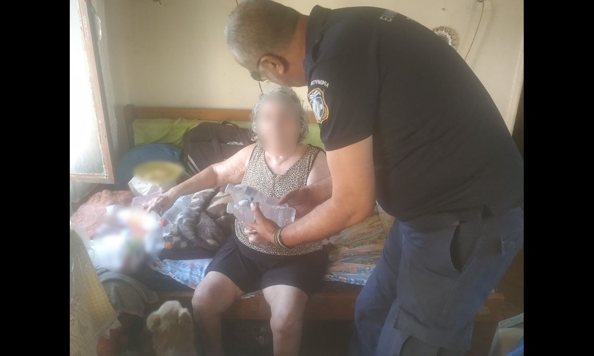 Αστυνομικός προσφέρει μπουκαλάκια με νερό σε ηλικιωμένη