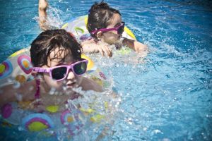 δυο κοριτσάκια κολυμπάνε φορώντας σωσίβια