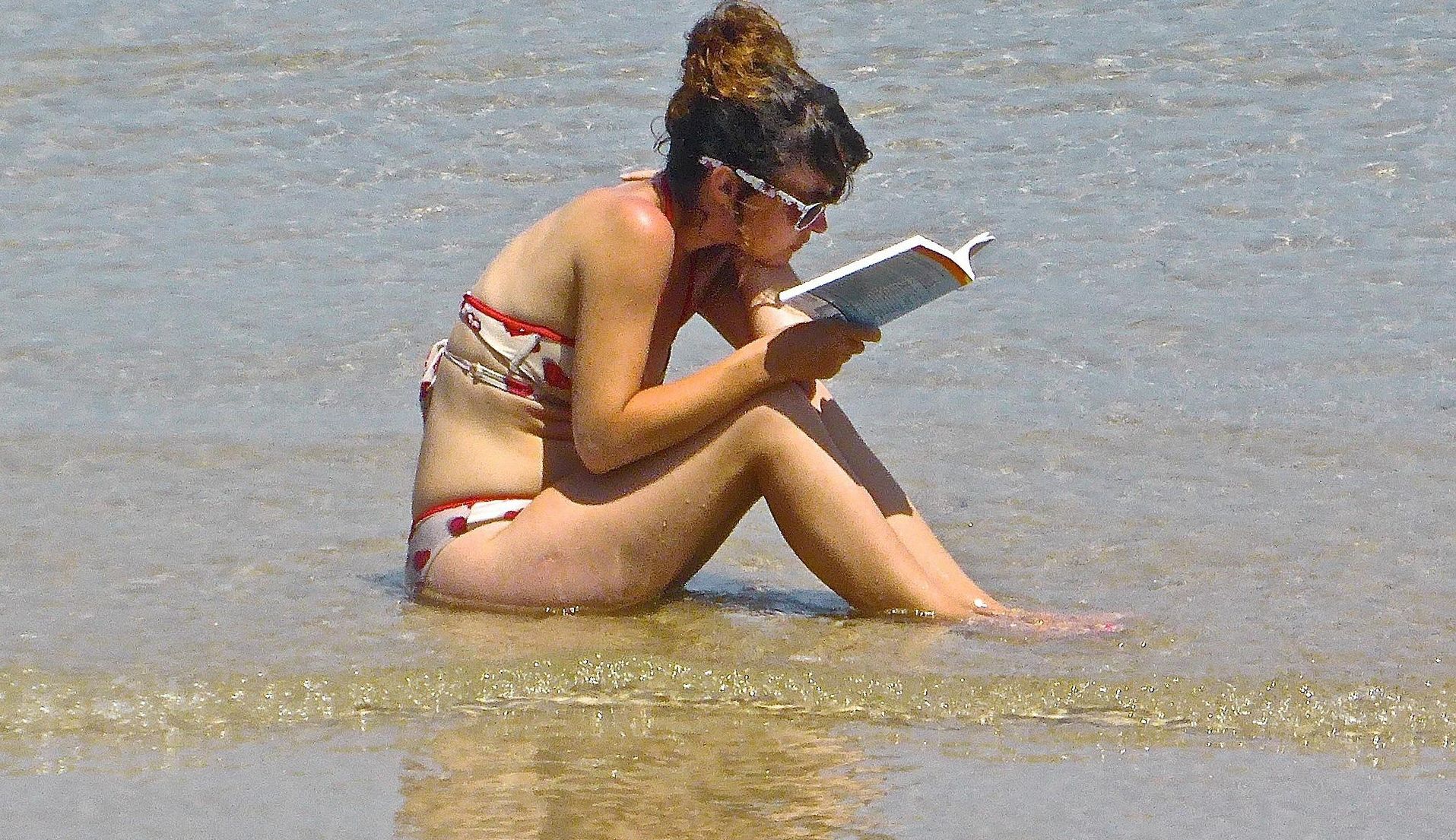 Γυναικα με μαγιώ διαβάζει στη θάλασσα