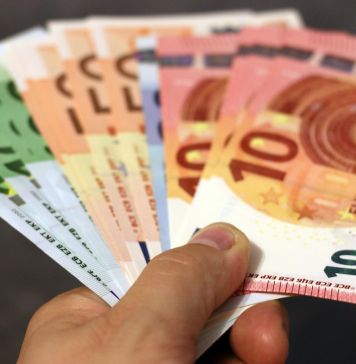 χέρι που κρατάει χρήματα σε ευρώ