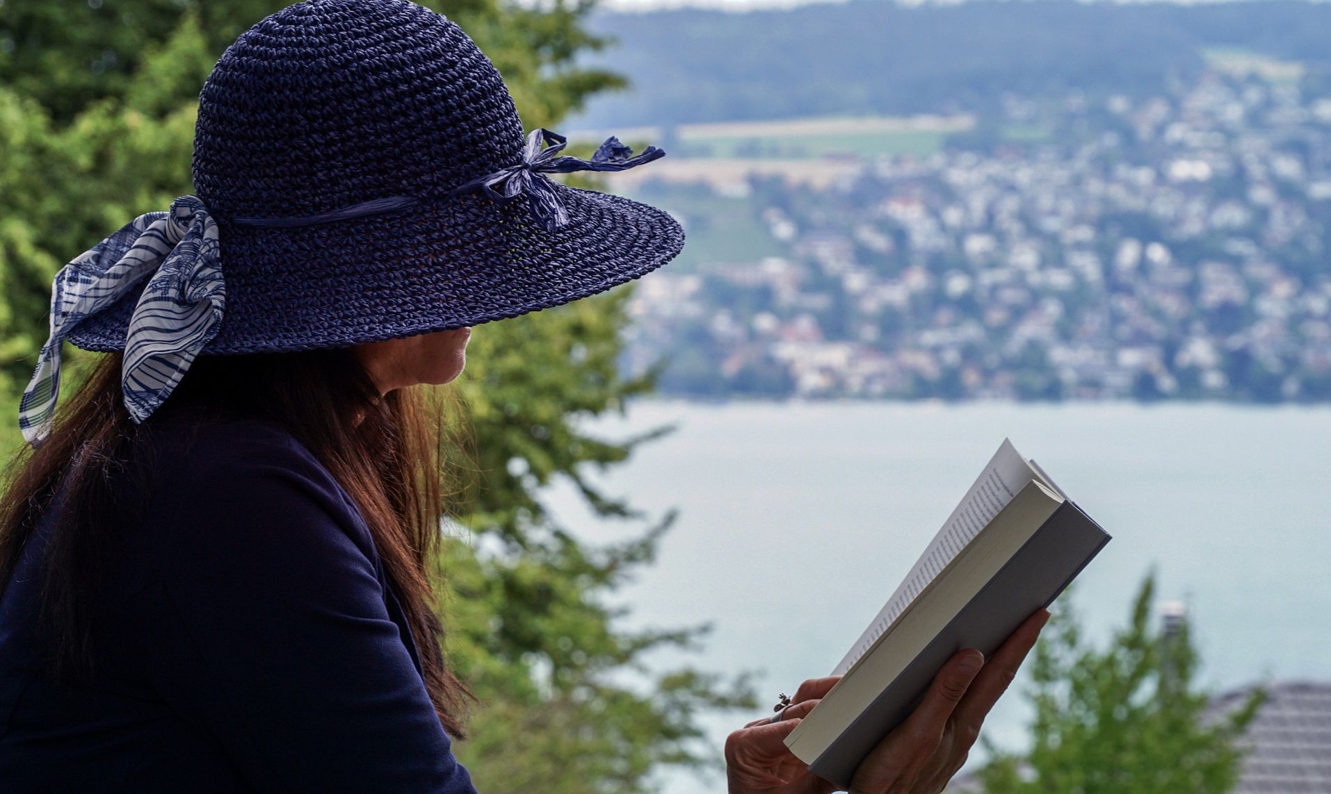 γυναίκα διαβαζει μπροστά σε λίμνη