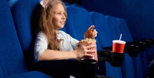 Μικρό κορίτσι βλεπει κινηματογραφο τρώγοντας ποπ κορν