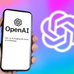 A hand holding a phone with the OpenAI website on the screen