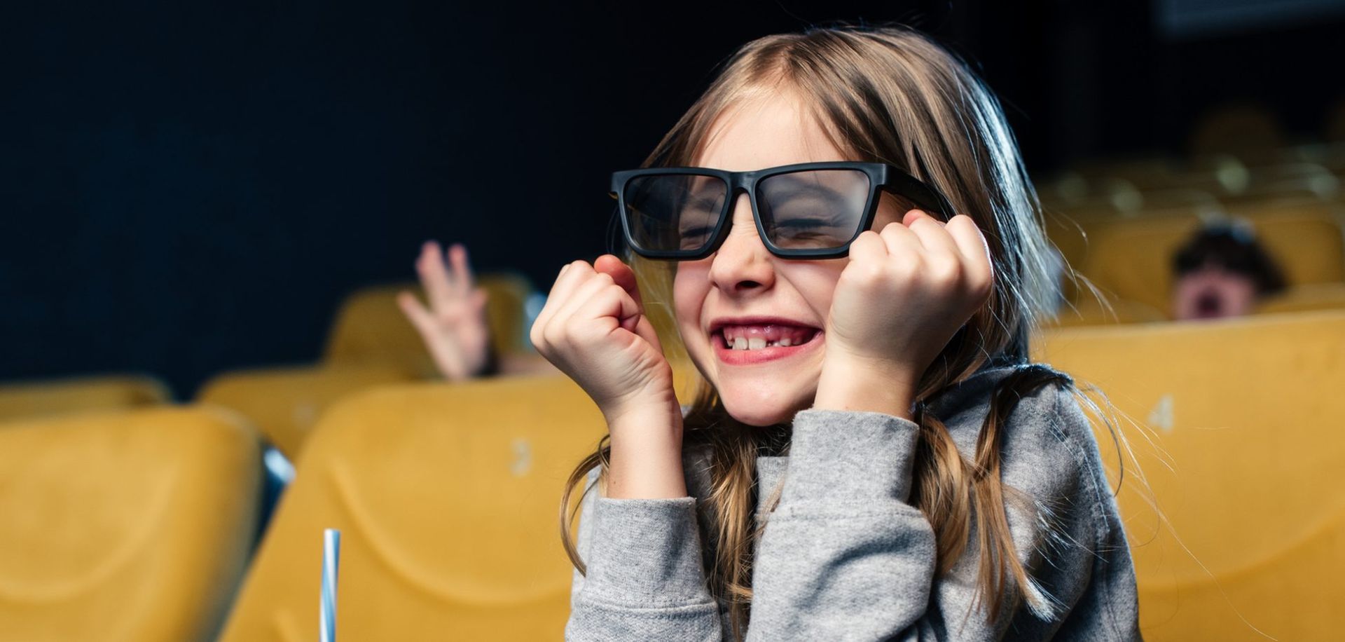 κοριτσάκι παρακουθεί ενθουσιασμένο κινηματογραφο φορωντας ειδικα γυαλιά