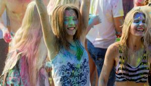 Young people, boys and girls have fun during Holi holiday, throwing colorful powder into each other. Festival of Colored Paint. festival of colors love. Color fest