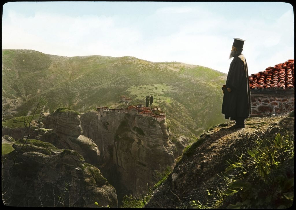 Μετέωρα. Μοναχός στέκεται στο βράχο της μονής του Μεγάλου Μετεώρου και αγναντεύει την μονή Βαρλαάμ που βρίσκεται στον απέναντι βράχο.