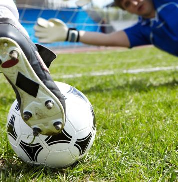 Horizontal image of soccer ball with foot of player kicking it