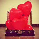 heart-shaped balloons in an old suitcase