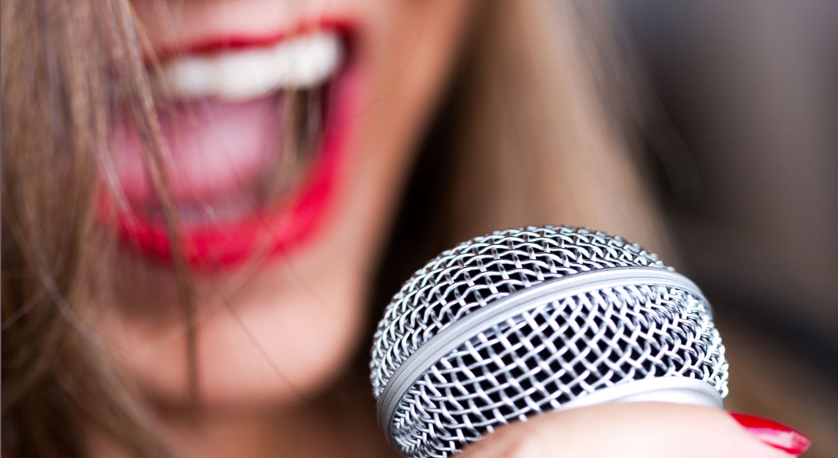 Γυναίκα καλλιτέχνης τραγουδα μπροστά σε ένα μικρόφωνο