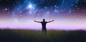 Ανθρωπος με ανοιχτα χέρια θαυμάζει τον ουρανό και τα άστρα τη νύχτα