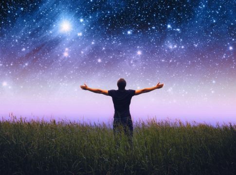 Ανθρωπος με ανοιχτα χέρια θαυμάζει τον ουρανό και τα άστρα τη νύχτα