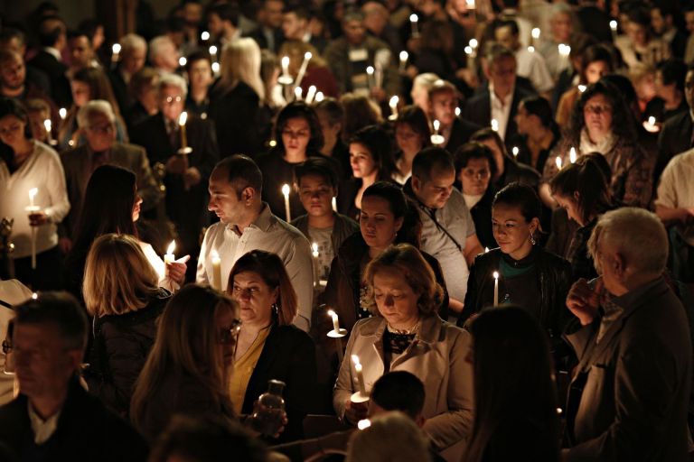 πληθος πιστων με αναμμένα κεριά γιορτάζει την Ανάσταση
