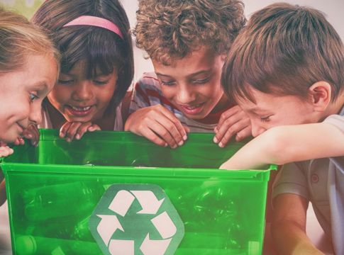 Παιδια κοιτάζουν μέσα σε κάδο ανακύκλωσης για πλαστικά μπουκάλια
