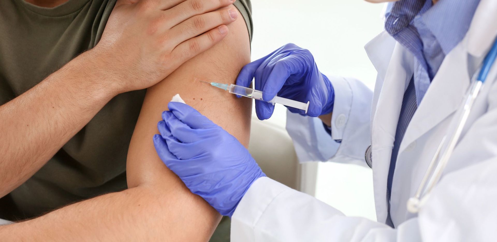 Γιατρος εμβολιάζει άνδρα στο χέρι