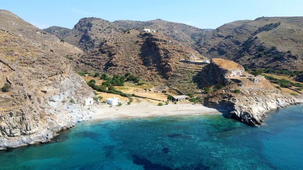 Αεροφωτογραφία παραλίας με τυρκουάζ νερά δίπλα σε αρχαιολογικό χώρο με ερείπια αρχαίου θεάτρου πάνω σε βραχώδη ακτή ελληνικού νησιού, Κέας
