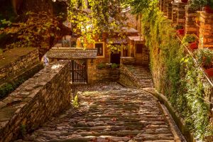 πέτρινο καλντερίμι στη μακρινίτσα πηλίου με παραδοσιακά σπίτια και πράσινο